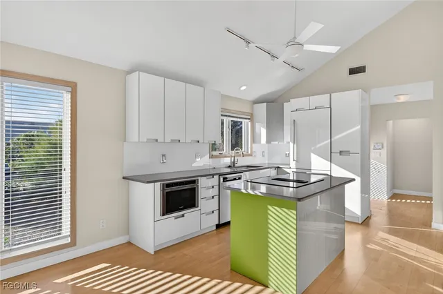 a kitchen with kitchen island stainless steel appliances granite countertop a stove a sink and a refrigerator