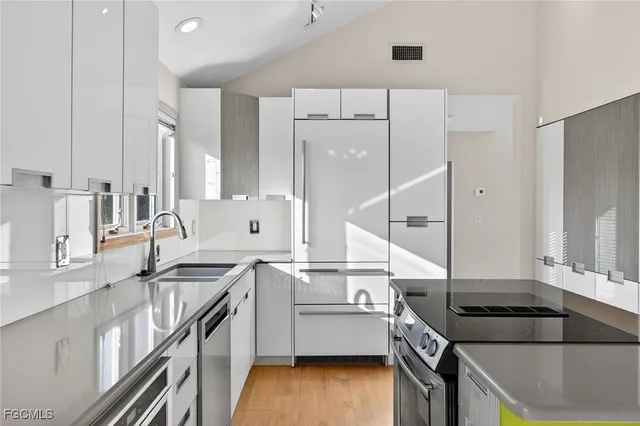 a kitchen that has a sink a stove and a wooden floor