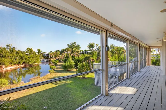 a view of a balcony with floor to ceiling windows wooden floor and yard