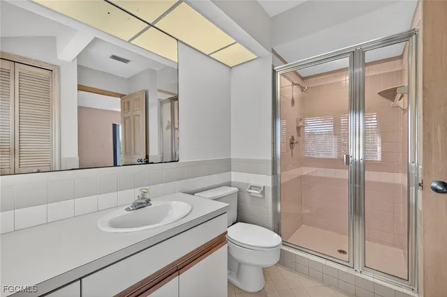 a bathroom with a sink toilet a mirror and shower