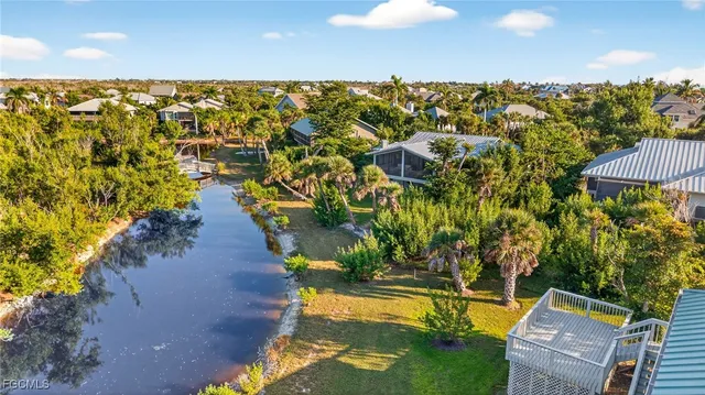 an aerial view of residential houses with outdoor space and trees