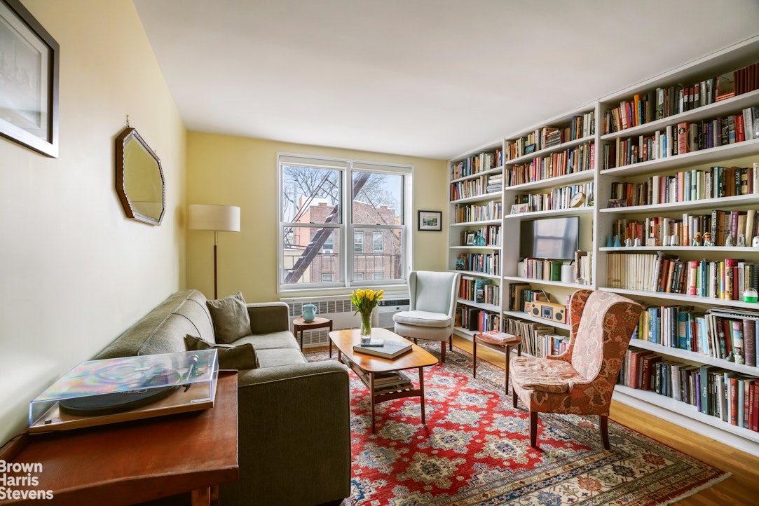 39-76 57th Street, Unit 4G Queens, NY 11377 - Photo 2 of 8 a living room with furniture and a book shelf
