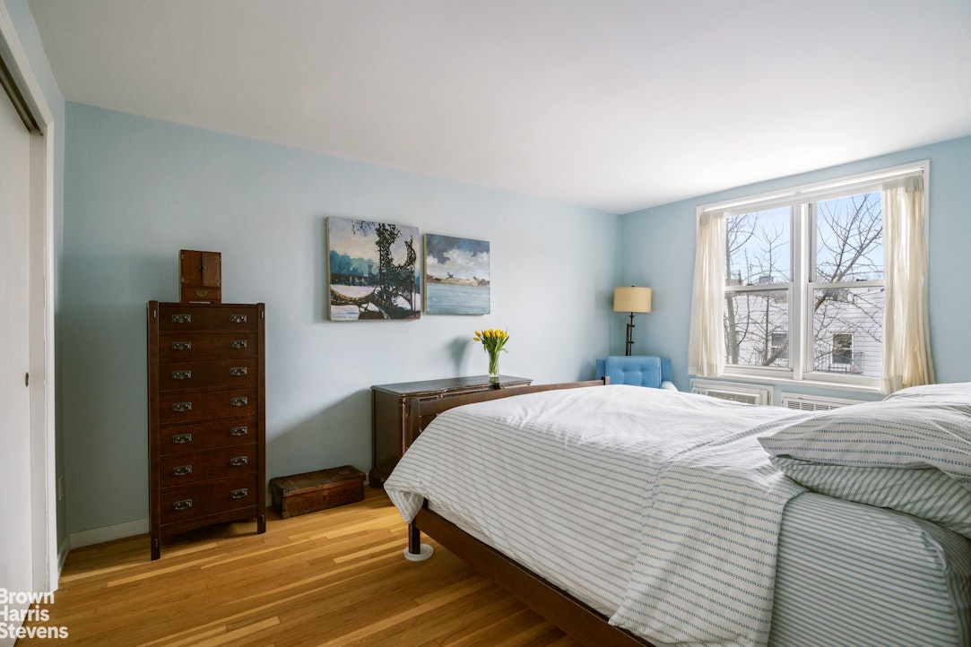 39-76 57th Street, Unit 4G Queens, NY 11377 - Photo 4 of 8 a bedroom with a bed and a window