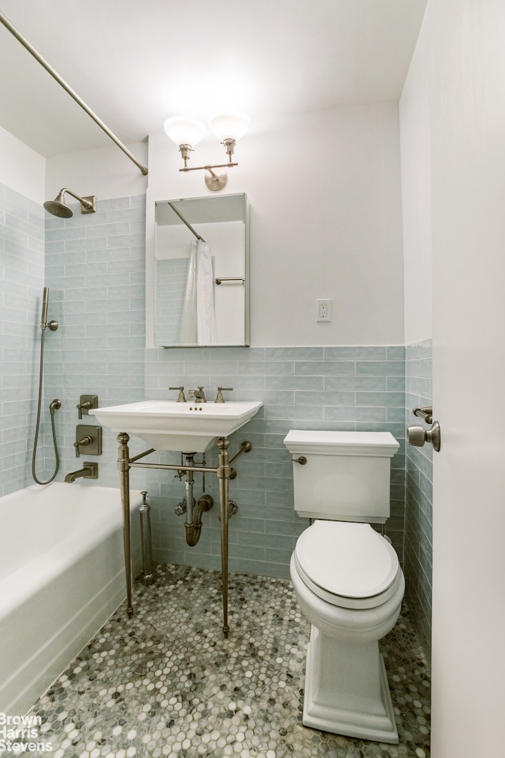 39-76 57th Street, Unit 4G Queens, NY 11377 - Photo 5 of 8 a white toilet sitting next to a bathroom sink