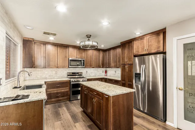a kitchen with granite countertop a sink stove and refrigerator