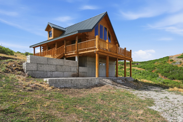 20 Q Puma Road Fairview, UT 84629 - Photo 25 of 27 Log cabin exterior featuring a metal roof, dormer window, and an expansive deck with wood railing