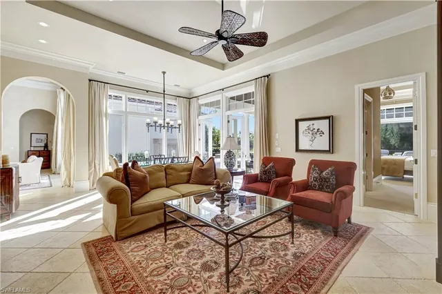 a living room with furniture a ceiling fan and a rug