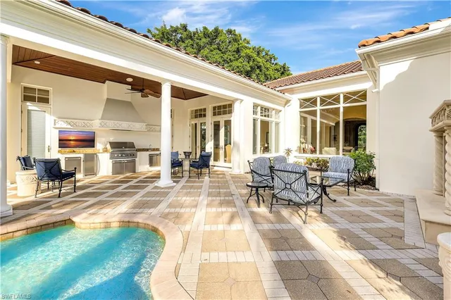 a view of a patio with dining table and chairs with the couches near an umbrella