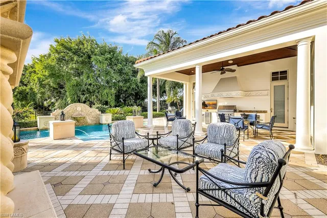 a view of a patio with a dining table and chairs with couches potted plants and a sky view