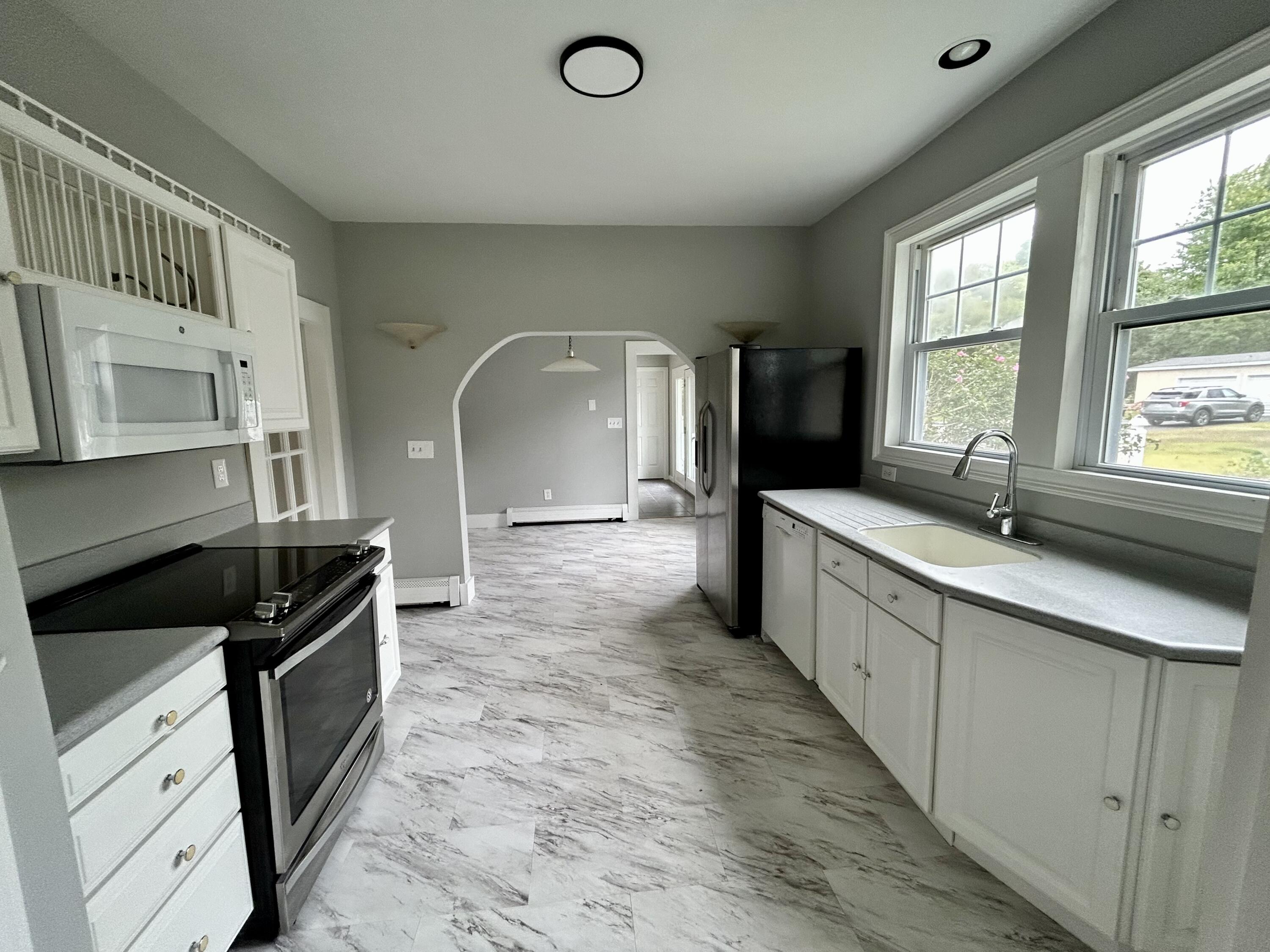 83 Marion Road Wareham, MA 02571 - Photo 21 of 32 a kitchen with a sink stove and cabinets