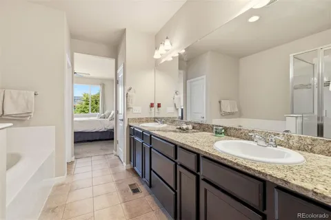 a en suite bathroom with a granite countertop sink and a mirror