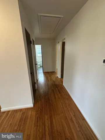 a view of a hallway with wooden floor and stairs