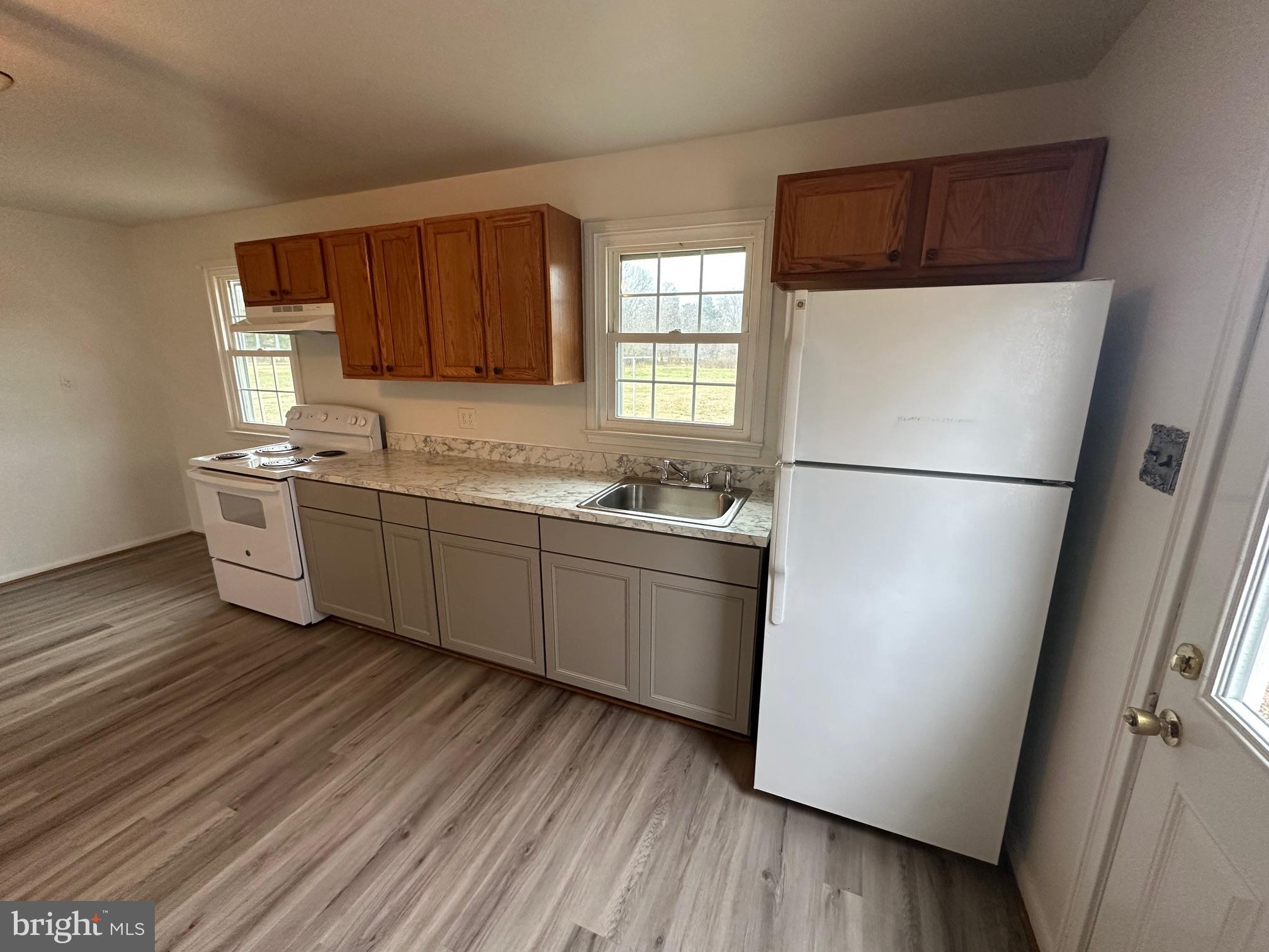 14835 Rock Point Road Newburg, MD 20664 - Photo 3 of 13 a kitchen with a sink a refrigerator a window and cabinets