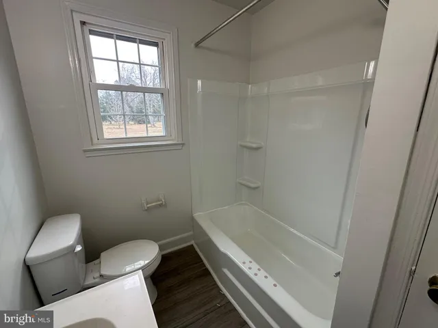 a white toilet sitting next to a bath tub