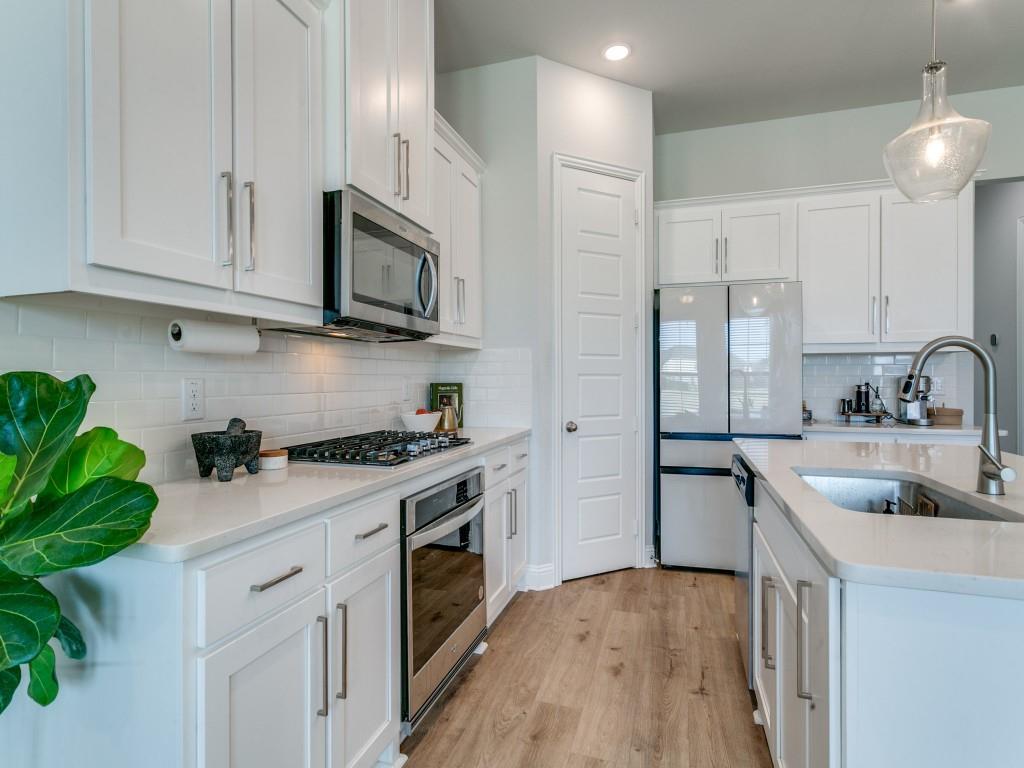 12964 Rockham Lane Dallas, TX 75234 - Photo 6 of 24 a kitchen with stainless steel appliances granite countertop a sink a stove and a refrigerator