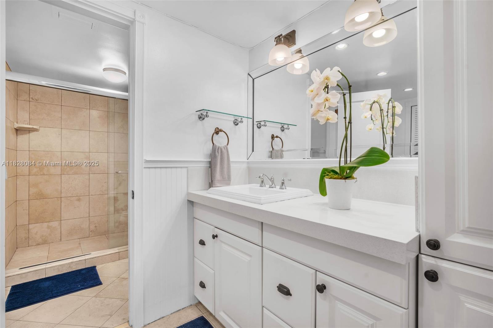 611 Ocean Drive, Unit 3E Key Biscayne, FL 33149 - Photo 12 of 30 a bathroom with a granite countertop sink a potted plant and a shower