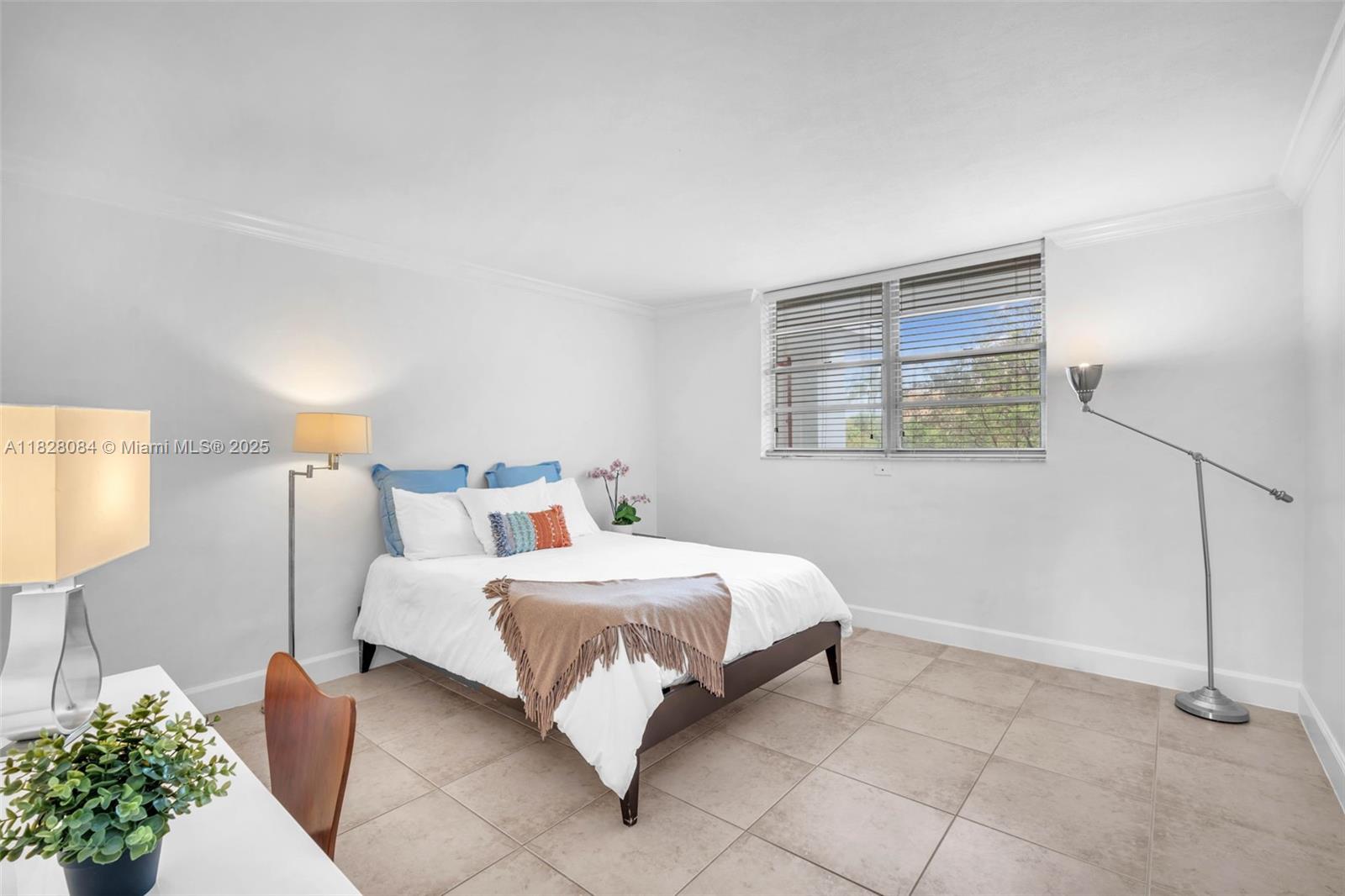 611 Ocean Drive, Unit 3E Key Biscayne, FL 33149 - Photo 15 of 30 a bedroom with a bed and a lamp on table