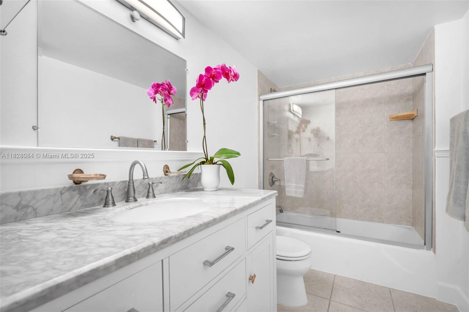611 Ocean Drive, Unit 3E Key Biscayne, FL 33149 - Photo 17 of 30 a bathroom with a granite countertop sink a toilet and shower