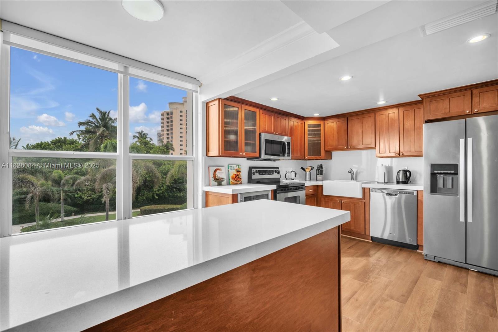 611 Ocean Drive, Unit 3E Key Biscayne, FL 33149 - Photo 6 of 30 a kitchen with white cabinets and stainless steel appliances