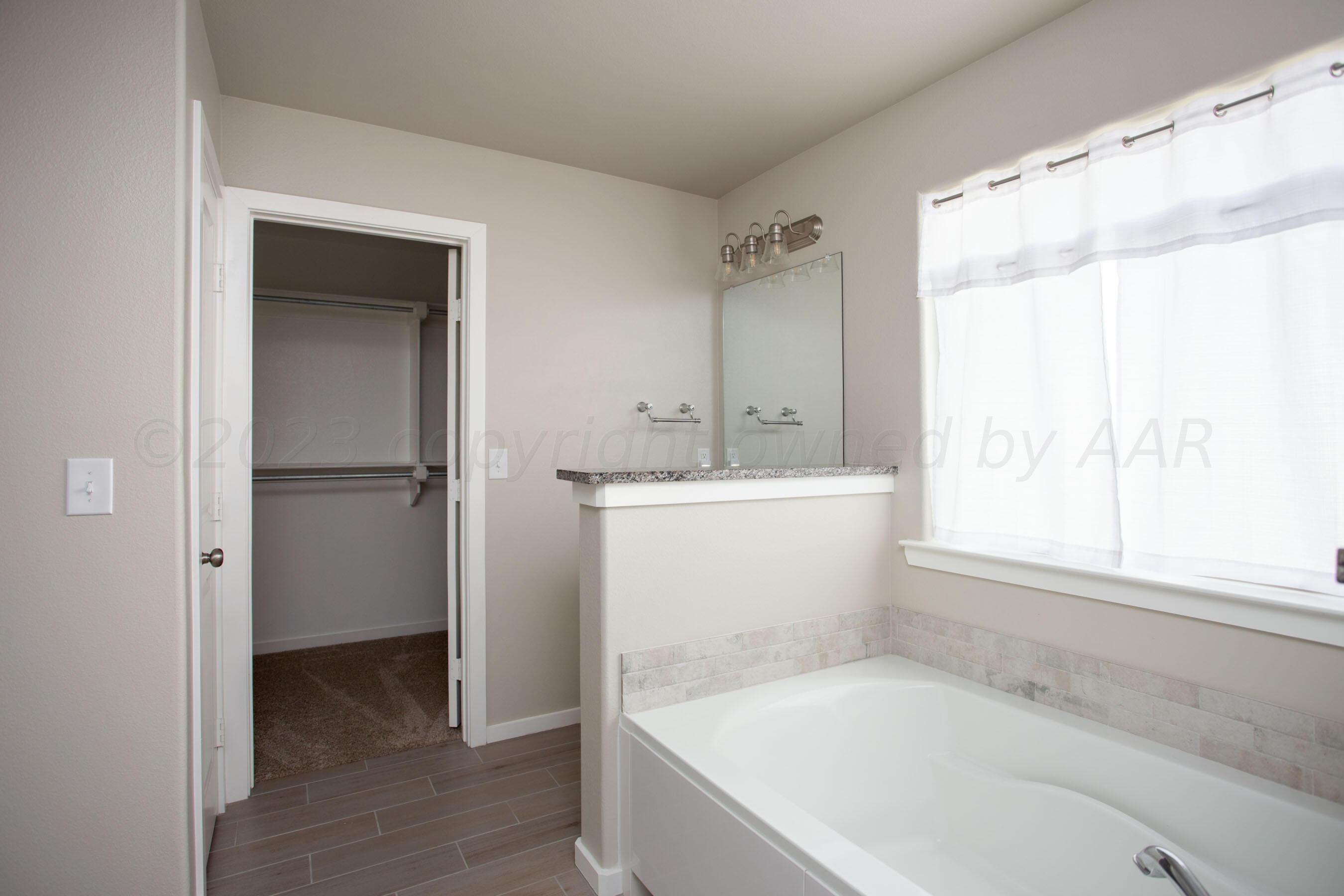 7811 Bellamy Drive Amarillo, TX 79119 - Photo 12 of 24 a bathroom with a bathtub and a sink