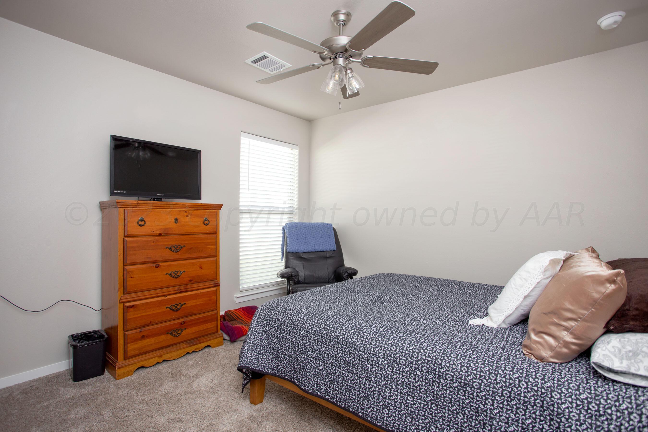 7811 Bellamy Drive Amarillo, TX 79119 - Photo 16 of 24 a bedroom with a bed and a television