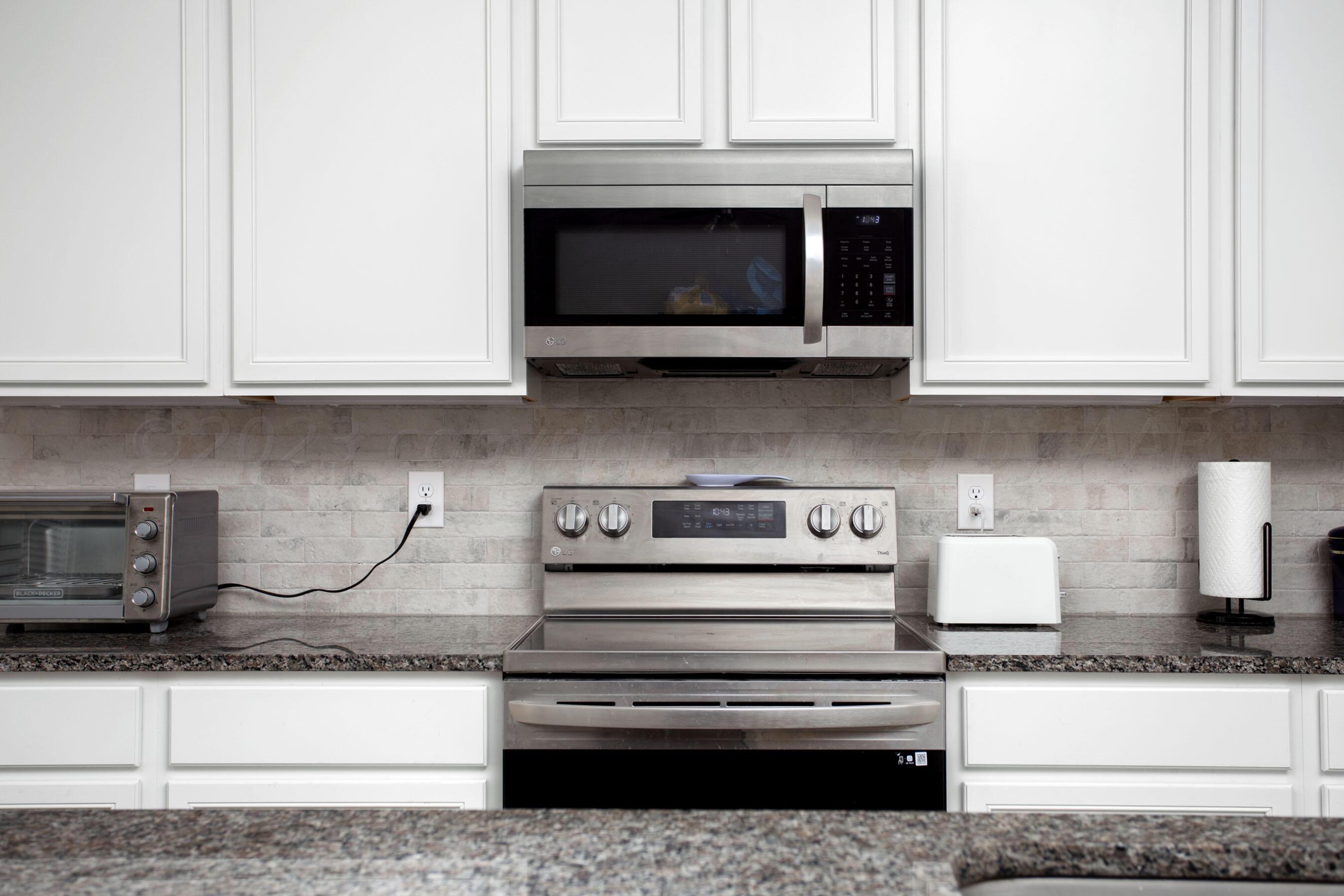 7811 Bellamy Drive Amarillo, TX 79119 - Photo 7 of 24 a kitchen with granite countertop a stove and a microwave