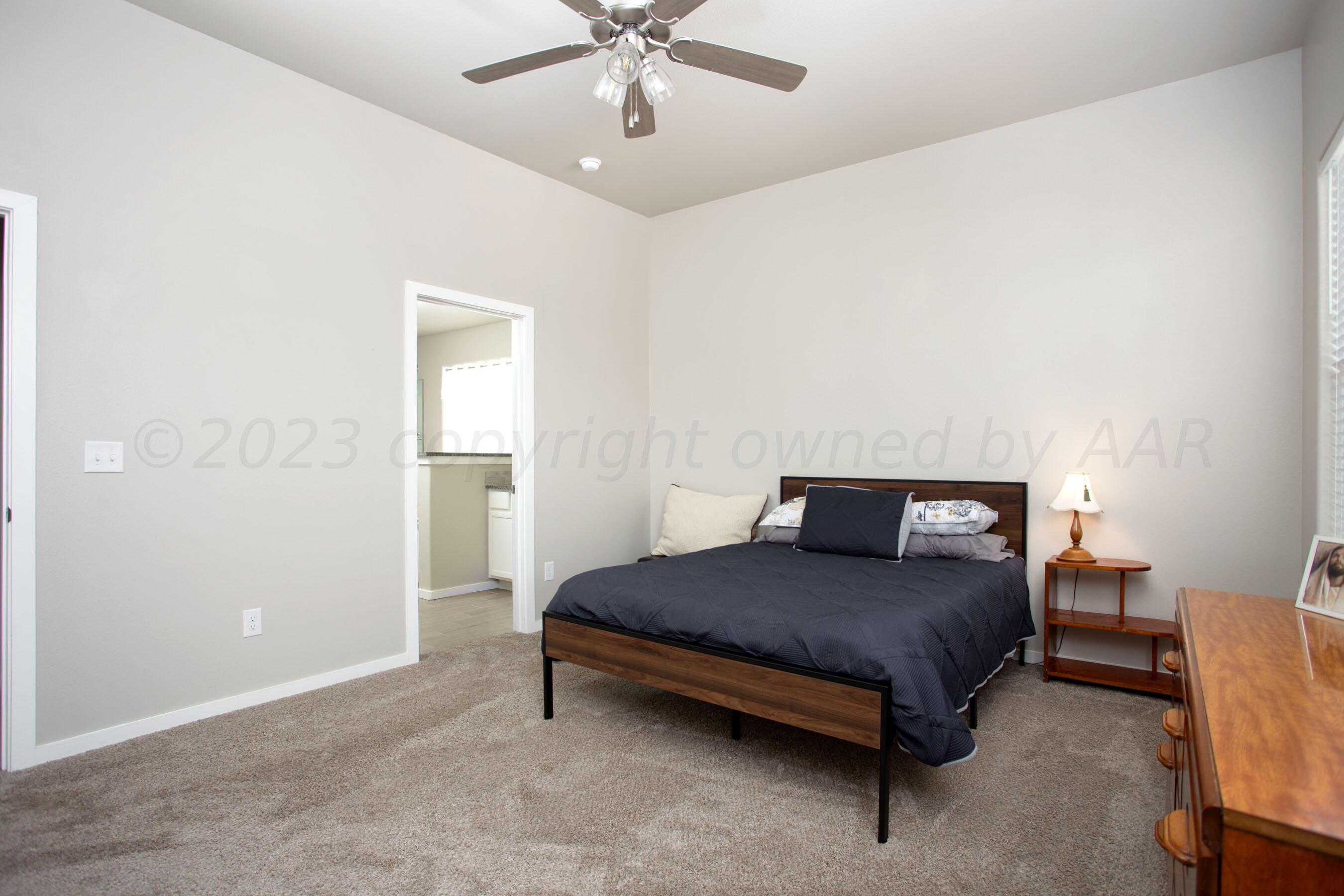 7811 Bellamy Drive Amarillo, TX 79119 - Photo 10 of 24 a bedroom with a bed and a chandelier