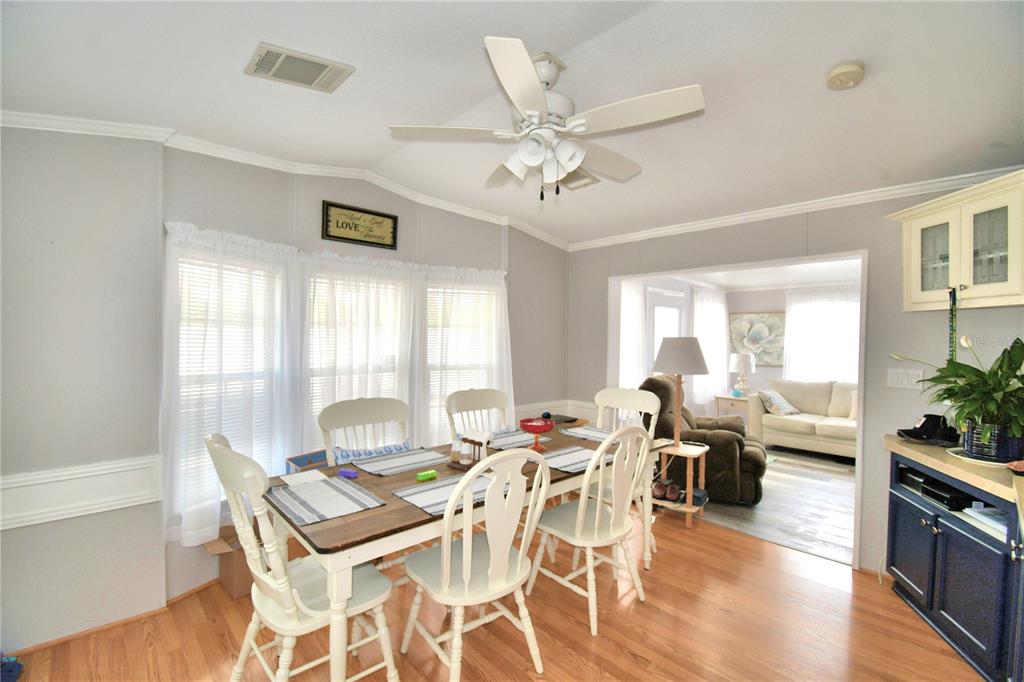 251 Patterson Road, Unit I58 Haines City, FL 33844 - Photo 14 of 52 a dining room with wooden floor a chandelier fan a wooden table and chairs