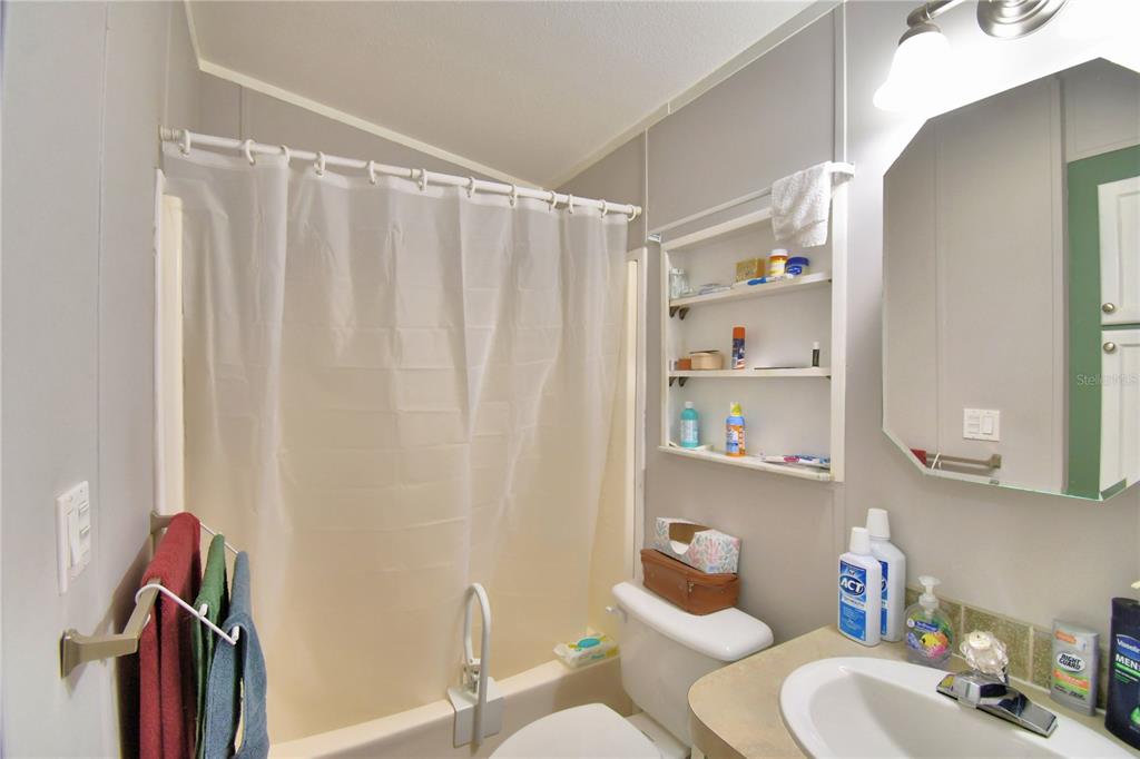 251 Patterson Road, Unit I58 Haines City, FL 33844 - Photo 22 of 52 a bathroom with a sink a toilet and a shower curtain