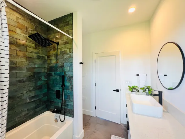 a bathroom with a tub shower and sink