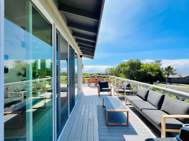 a balcony with wooden floor and outdoor seating