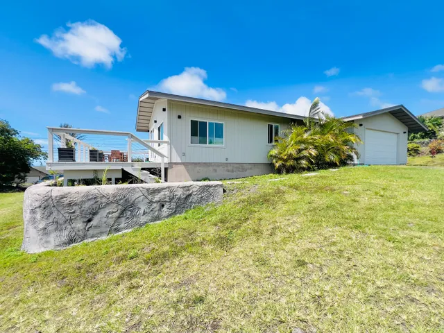 a large tree in front of a house with a yard