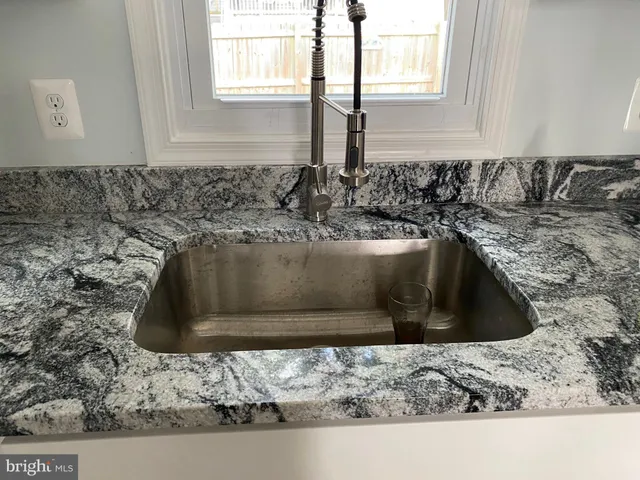 a kitchen sink with a granite counter top