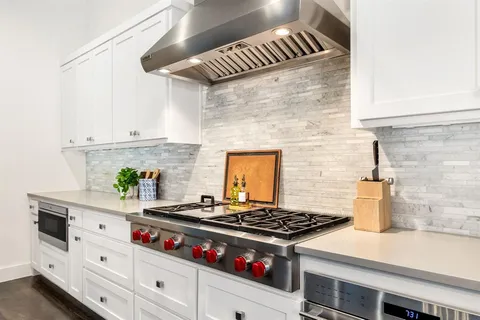 a stove top oven sitting inside of a kitchen