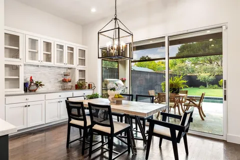 a dining room with furniture a chandelier and wooden floor