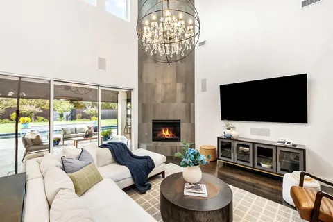 a living room with furniture a flat screen tv and a fireplace