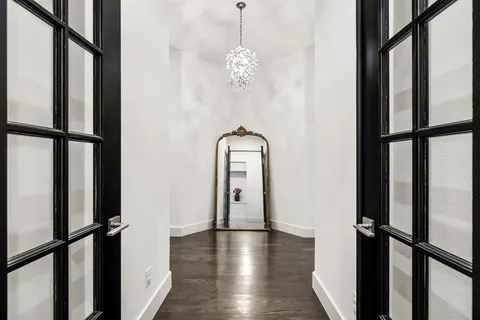 a view of a hallway with wooden floor and staircase