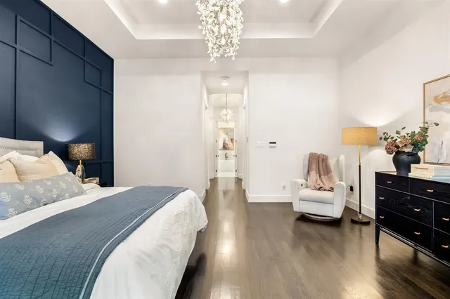 a spacious bedroom with a bed and wooden floor