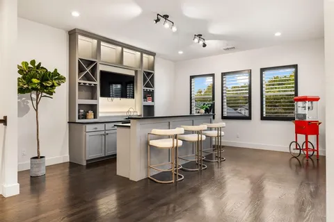 a living room with furniture kitchen and a flat screen tv