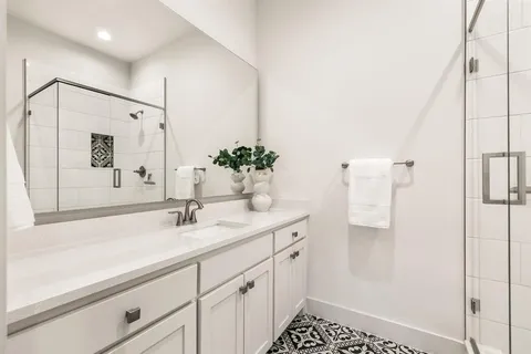 a spacious bathroom with a shower sink and mirror
