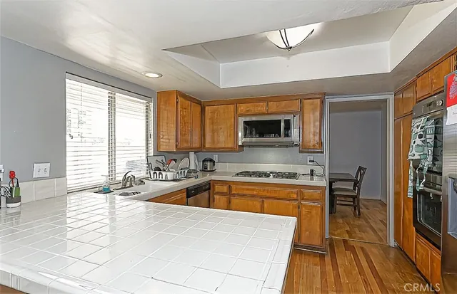 a kitchen with a sink a counter top space and stainless steel appliances