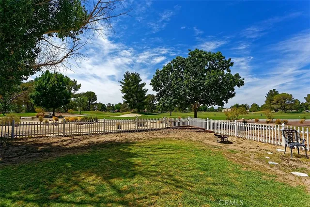 a view of a yard with wooden fence
