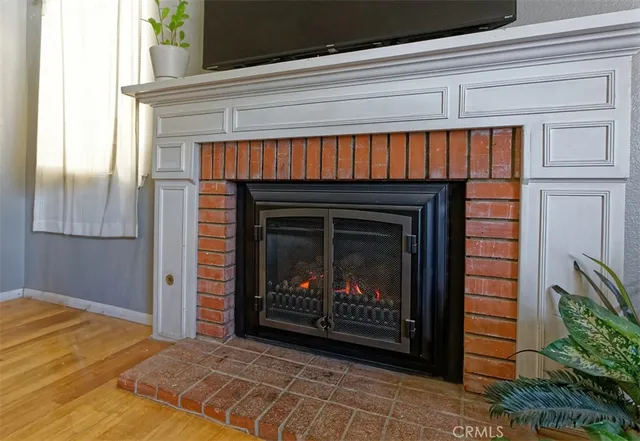 a view of an empty room with fire place and a window