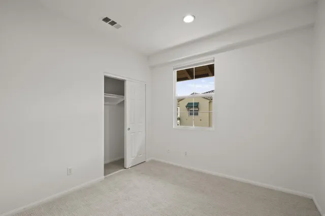 an empty room with a hallway and closet