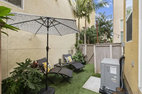 a backyard of a house with table and chairs potted plants