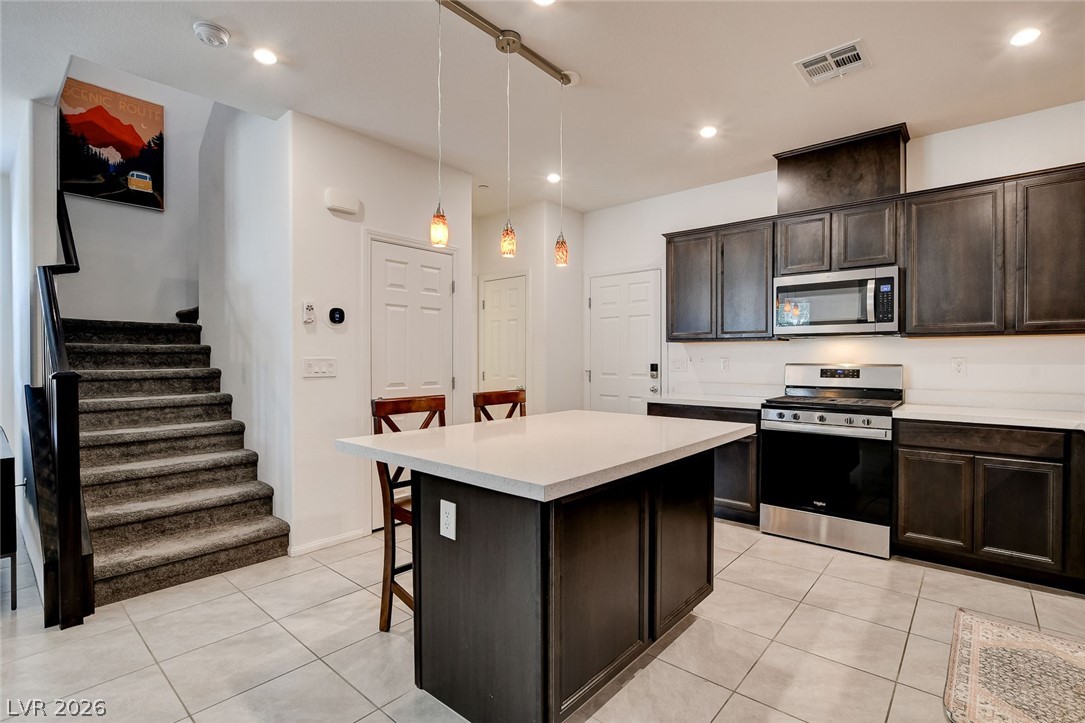484 Filaree Place Henderson, NV 89015 - Photo 18 of 71 This modern kitchen features sleek cabinetry, a spacious island, and contemporary appliances, ideal for culinary endeavors.