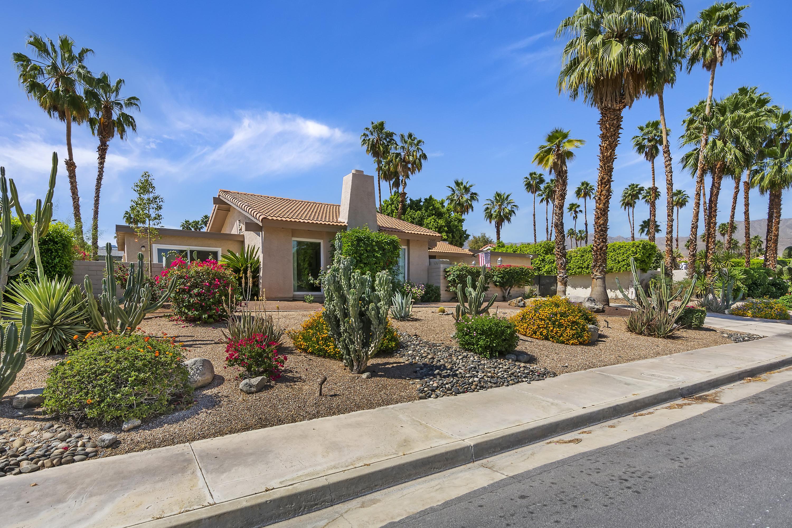 73149 Haystack Road Palm Desert, CA 92260 - Photo 3 of 32 a group of palm trees sitting in front of a house
