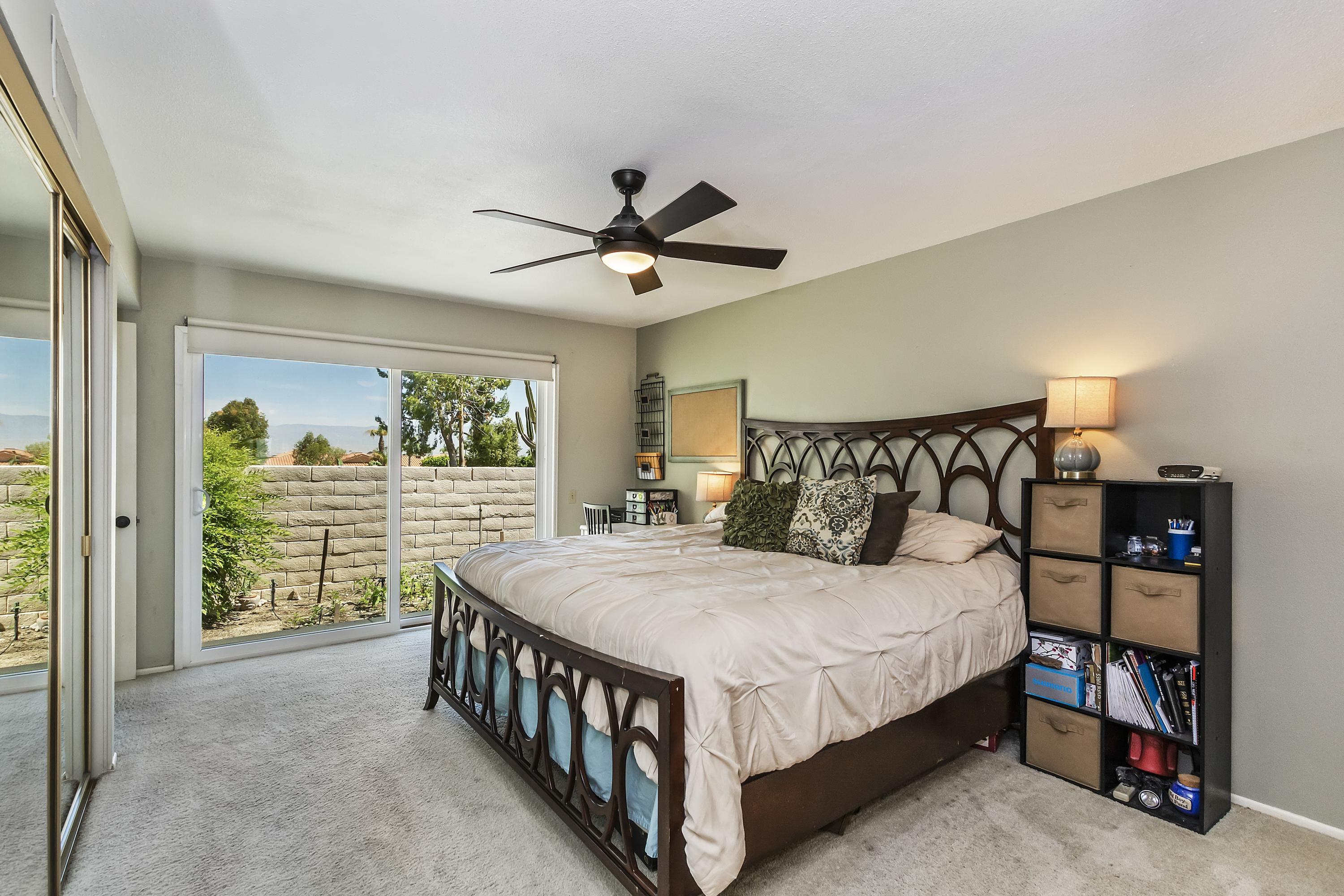 73149 Haystack Road Palm Desert, CA 92260 - Photo 22 of 32 a bedroom with a bed a large window with table and chairs