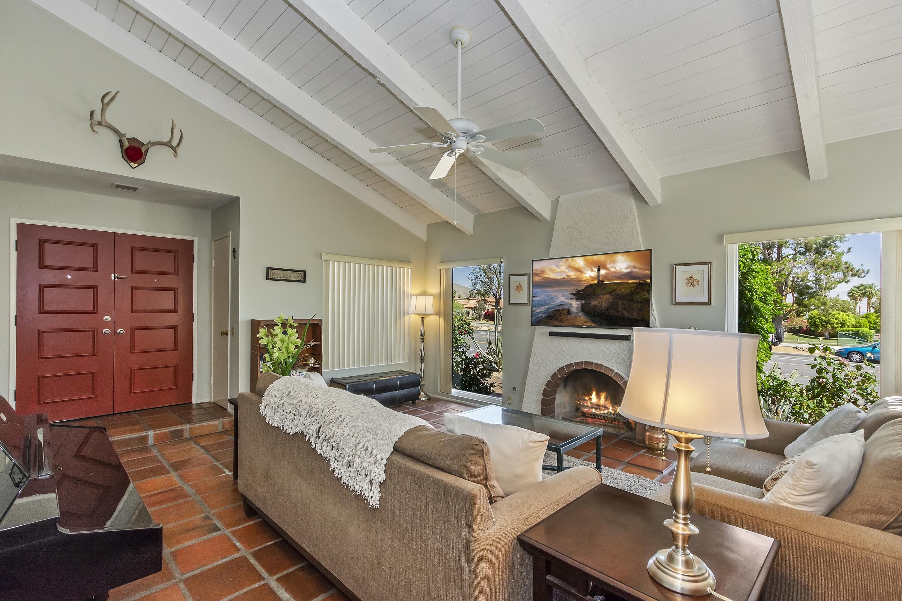 73149 Haystack Road Palm Desert, CA 92260 - Photo 6 of 32 a living room with furniture a fireplace and a flat screen tv