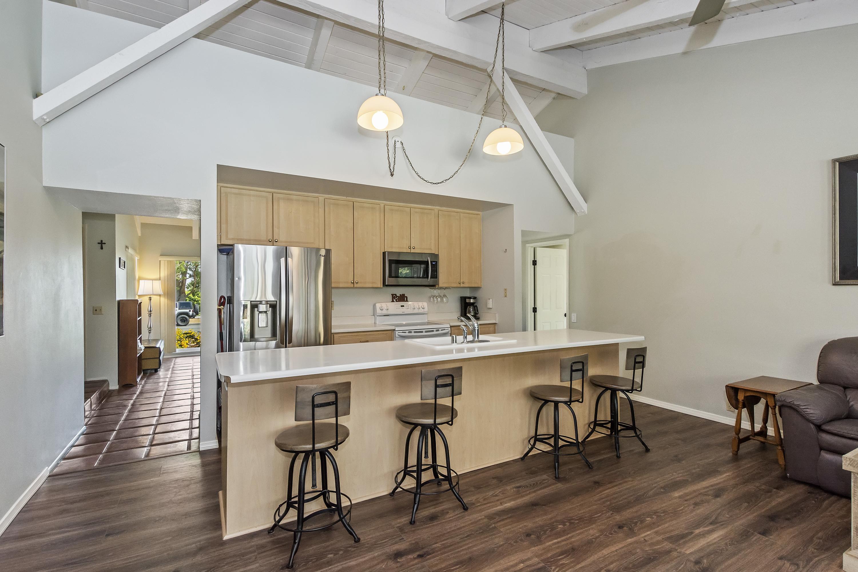 73149 Haystack Road Palm Desert, CA 92260 - Photo 9 of 32 a kitchen with stainless steel appliances a dining table chairs refrigerator and sink
